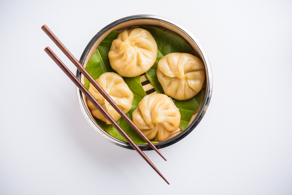 dumplings served in bowl with chopsticks on top